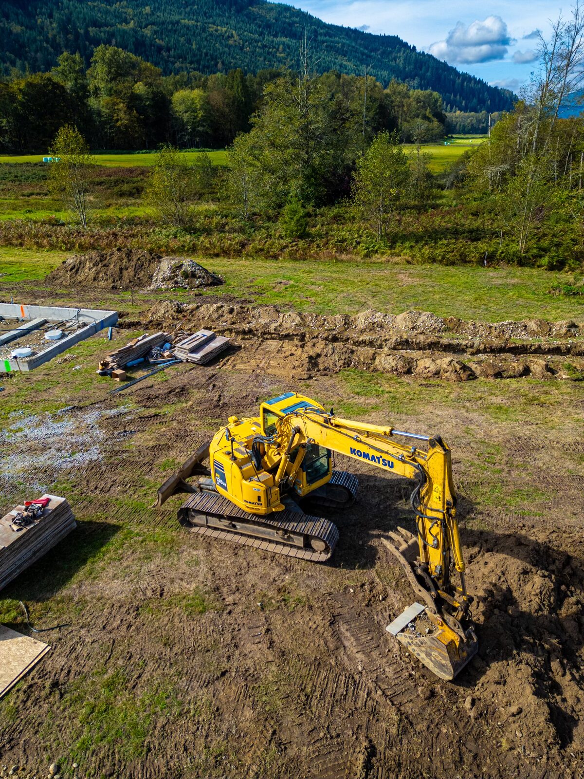 Yellow Komatsu excavator on a rural pad