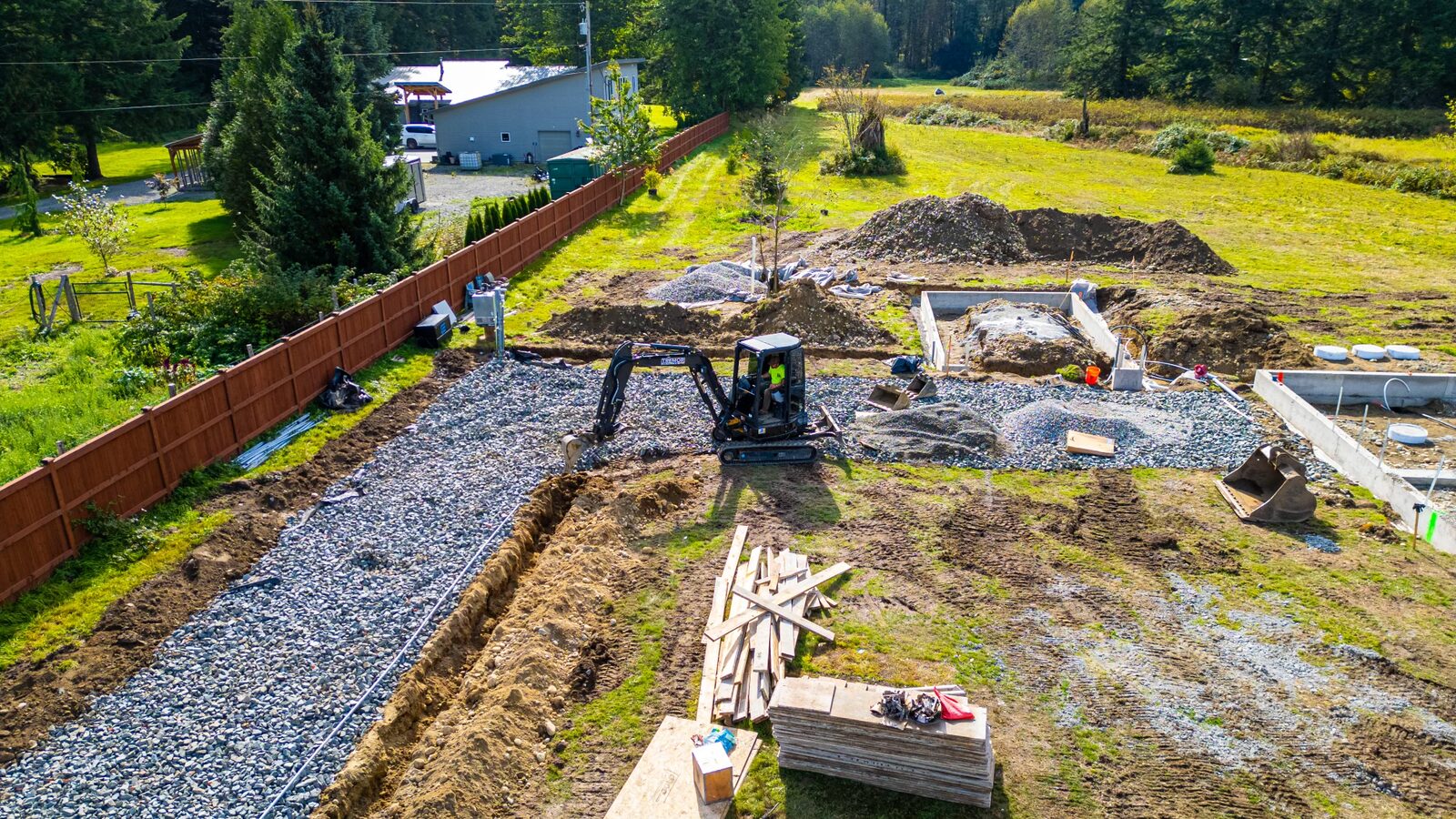 Aerial of a mini excavator working a gravel driveway